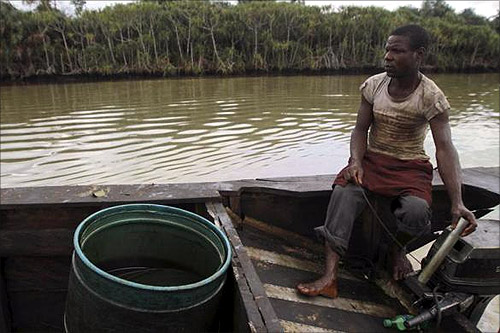 A labourer operates the engine of a locally built canoe, which contains a plastic drum used in siphoning crude oil for illegal refinery, along the Diebu creek in Nigeria's Bayelsa state May 15, 2012.
