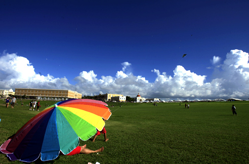 A family flies a kite in front of the Fort San Felipe del Morro