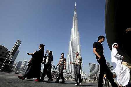 A group of Emiratis walk past the Burj Dubai Tower