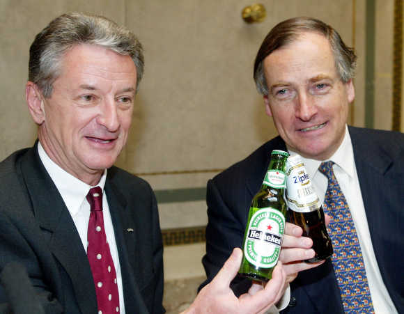 BBAG CEO Karl Buecher, left, and Heineken CEO Anthony Ruys toast with two bottles of beer in Vienna, in a file photo.