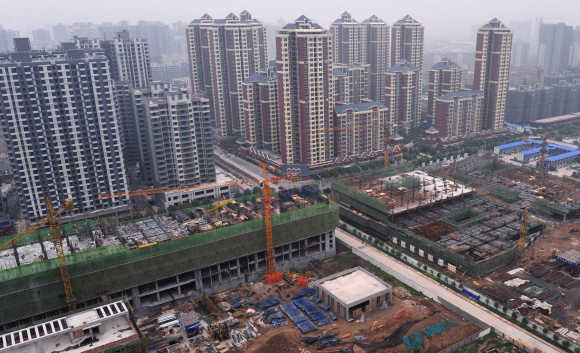 Newly constructed residential buildings are seen next to a construction site in Xi'an, Shaanxi province, China.