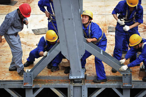 Labourers install a steel pillar at a construction site of the three-storey D3 cafeteria built by the Broad Group in Yueyang, Hunan province.