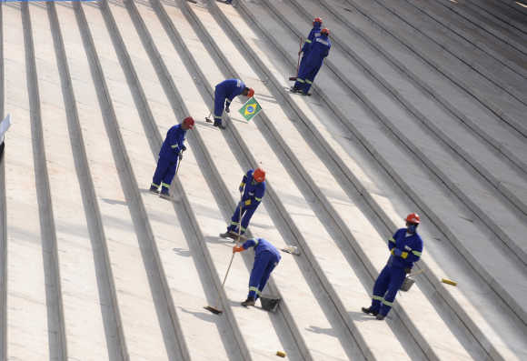 Workers smoothen concrete steps at the construction site of the Corinthians Stadium in the Sao Paulo neighbourhood of Itaquera, Brazil.