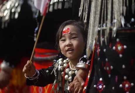 An ethnic Kachin girl waves a National League for Democracy flag