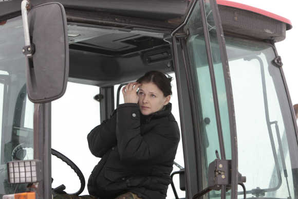 Ekaterina Shestakovskaya looks in the mirror as she drives a tractor in Kamenuki, 360km south-west of Minsk, Belarus.
