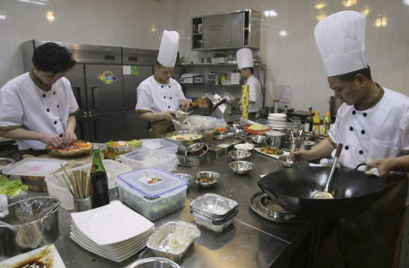Chefs prepare food inside the kitchen of an A380 theme restaurant in Chongqing municipality, China.