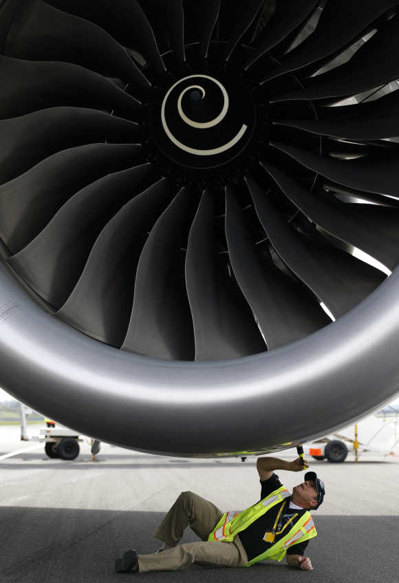 An engineer examines one of the engines of Boeing's new 787 Dreamliner aircraft at Manchester Airport.