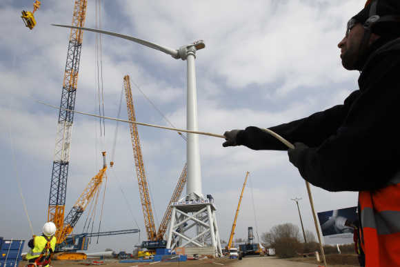 Technicians install a wind turbine blade at Alstom's offshore wind site in Le Carnet, on the Loire Estuary, near Saint Nazaire, France.