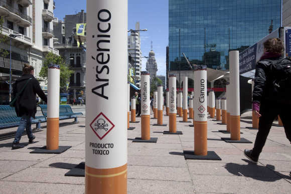 People walk past near an anti-tobacco installation in Montevideo, Uruguay.