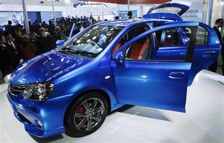 Onlookers stand next to Toyota's compact car 'Etios' at Auto Expo in New Delhi.