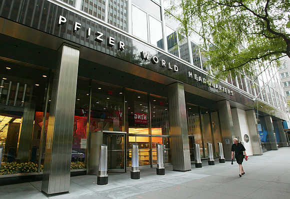 People pass the entrance of Pfizer World headquaters in New York City.