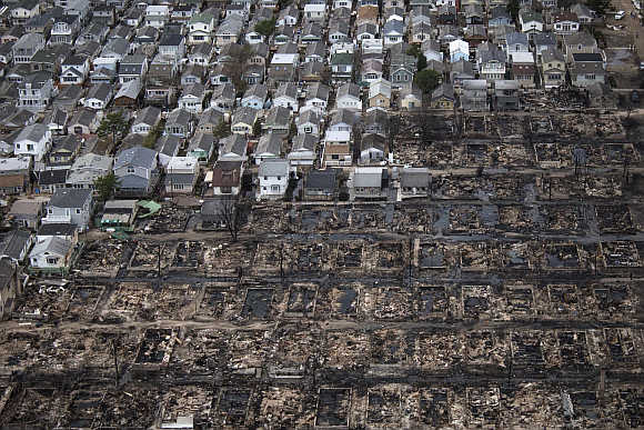 Burnt houses are seen next to those which survived in Breezy Point, a neighbourhood located in the New York City borough of Queens.