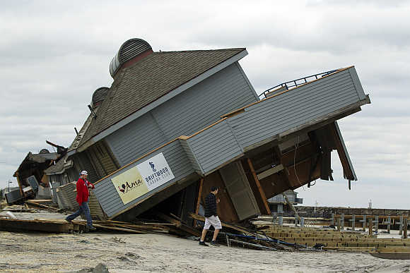 Men inspect damage to a beach club destroyed by Hurricane Sandy in Sea Bright, New Jersey.