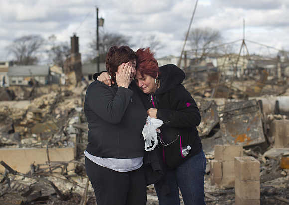 Neighbours Lucille Dwyer, right, and Linda Strong, left, embrace after looking through the wreckage of their homes devastated by fire and the effects of Hurricane Sandy in the Breezy Point section of the Queens borough of New York.