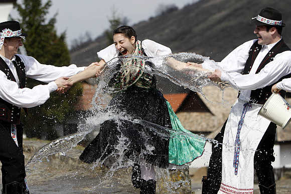 Boys hold on to a girl as they throw water at her as part of traditional Easter celebrations in Holloko, 100km east of Budapest.