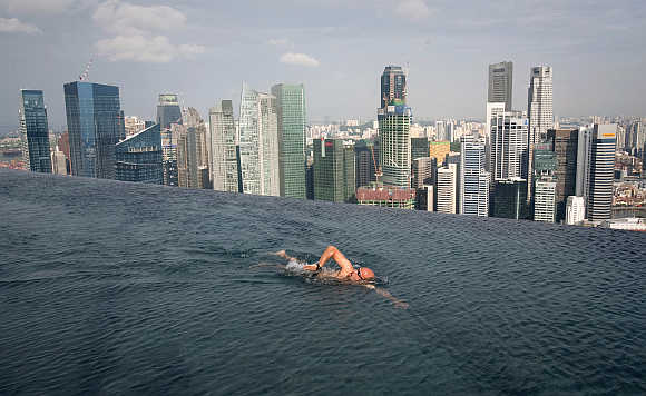 A guest swims in the infinity pool of the Skypark that tops the Marina Bay Sands hotel towers in Singapore.