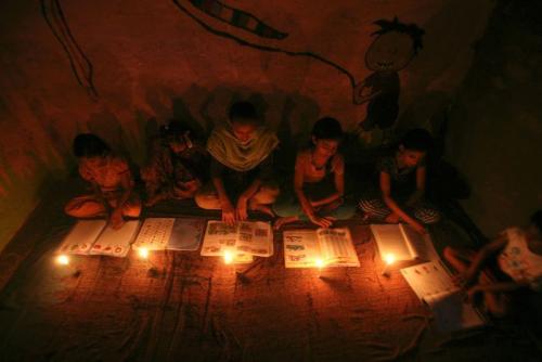 Girls study by candlelight inside a madrasa during a power-cut in Noida on the outskirts of New Delhi