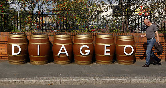 A man walks past barrels outside the Diageo Shieldhall facility near Glasgow, Scotland.