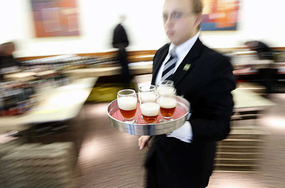 A server walks with a tray of beers during the Brussels Beer Challenge.
