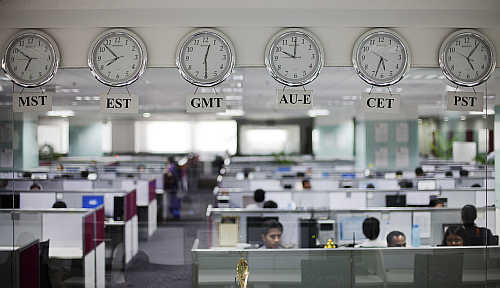 Workers are pictured beneath clocks displaying time zones in various parts of the world at an outsourcing centre in Bangalore.
