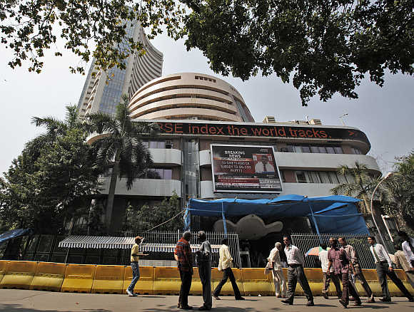 Commuters walk past the BSE building in Mumbai.