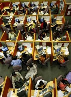 Employees seated in their cubicles at a call centre provide service support to international customers, in Bengaluru.