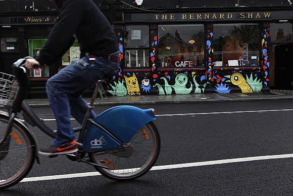 A cyclist rides past the Coffee To Get Her restaurant near Dublin city centre, which becomes a bar and club in the evenings.