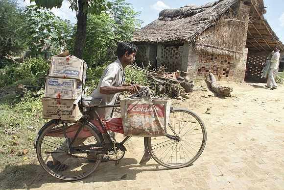 A salesman pushes his bicycle ladened with Colgate products in Hargaon, Uttar Pradesh.