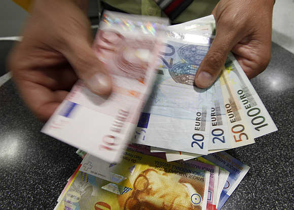A Swiss clerk exchanges francs into euros in Bern.