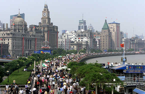 Thousands of tourists crowd along riverside Bund in Shanghai.