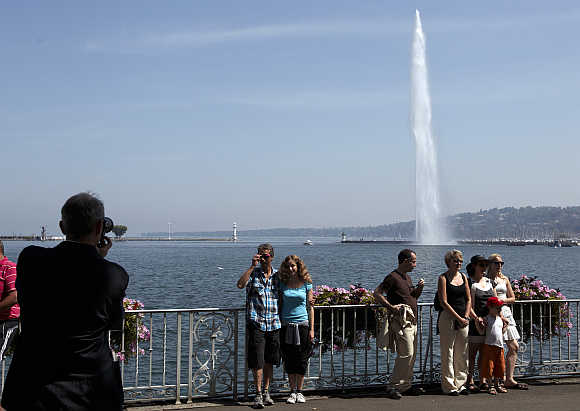 Tourists take a picture in front of the jet deau, or water fountain, in Geneva.