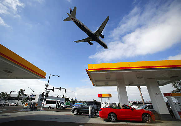 Consumers buy petrol as a plane approaches to land at the airport in San Diego, California.