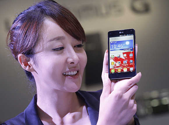 A woman holds LG's Optimus G smartphone in Seoul. The Optimus G runs on Google Android.