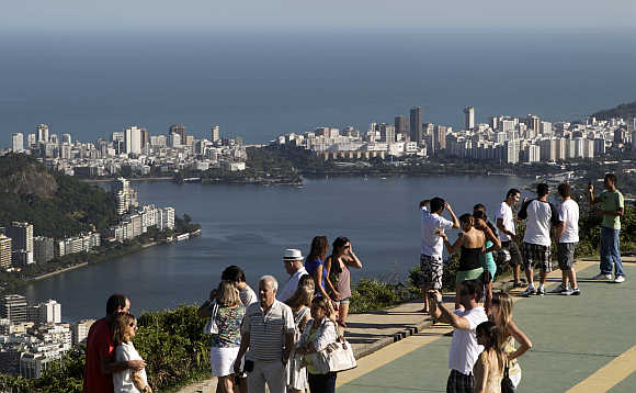 Tourists take pictures, with the Rodrigo de Freitas Lagoon in the background, in Rio de Janeiro.