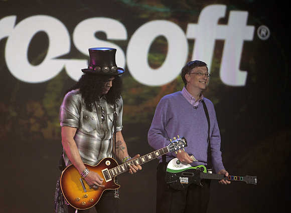 Slash, left, guitarist for Velvet Revolver band, plays next to Bill Gates in Las Vegas.