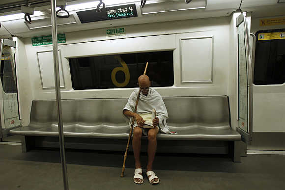 A man dressed as Gandhi in a Delhi metro.