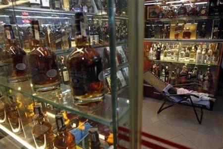 A child sleeps at a shop selling whisky in Hanoi.