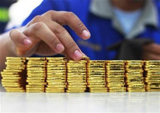 A person holds a gold piece, each weighing 100 grams