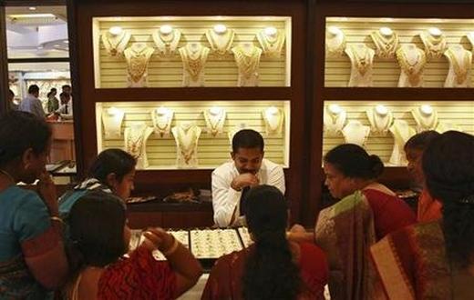 Customers check gold rings inside a gold jewellery showroom