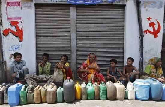 Residents wait outside a closed ration shop with their empty containers to collect kerosene in Kolkata