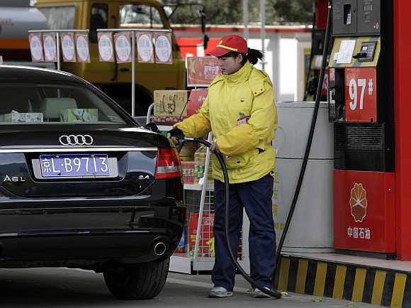 A station attendant fills up a car at a PetroChina petrol station in Beijing.