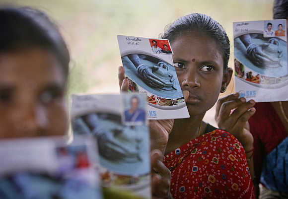 Loan borrowers show pass books given to them by a microfinance company at Ibrahimpatnam near Hyderabad.