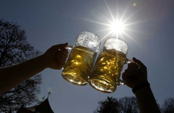 People toast with beer on a sunny day in Munich's English garden.