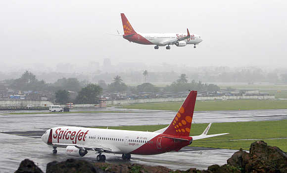 India's SpiceJet aircraft prepare for landing and take-off at the airport in Mumbai.