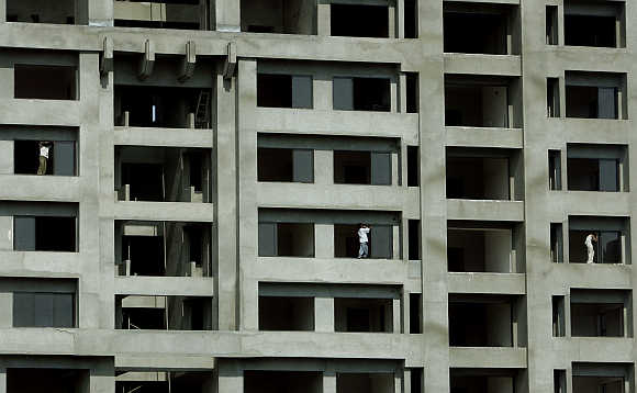 Workers install windows at a newly constructed building in Mumbai.