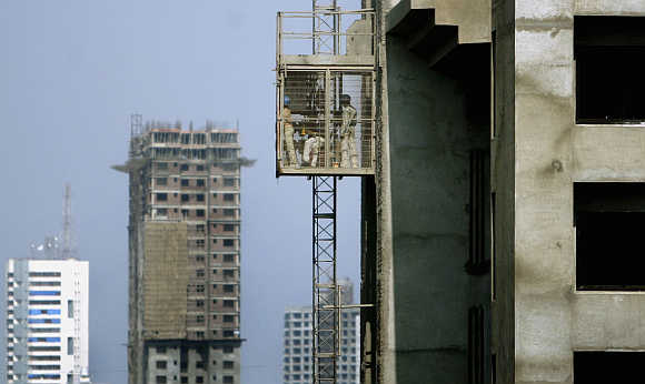 Workers use a lift at a construction site in Mumbai.
