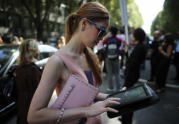 A woman looks at her iPad tablet after the Emporio Armani Spring/Summer 2013 collection at Milan Fashion Week.