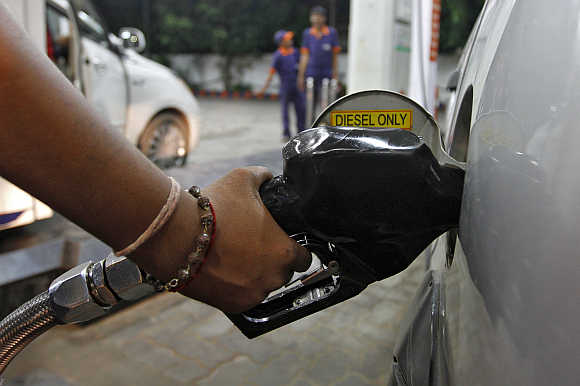 A worker fills a car with diesel at a fuel station in Ahmedabad.