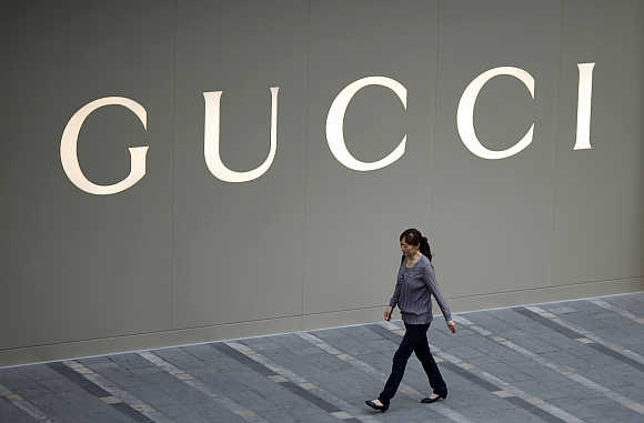 A woman walks by a Gucci luxury boutique at a mall in Shanghai.