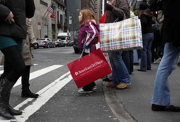 Shoppers carry bags as they walk down Fifth Avenue in New York.